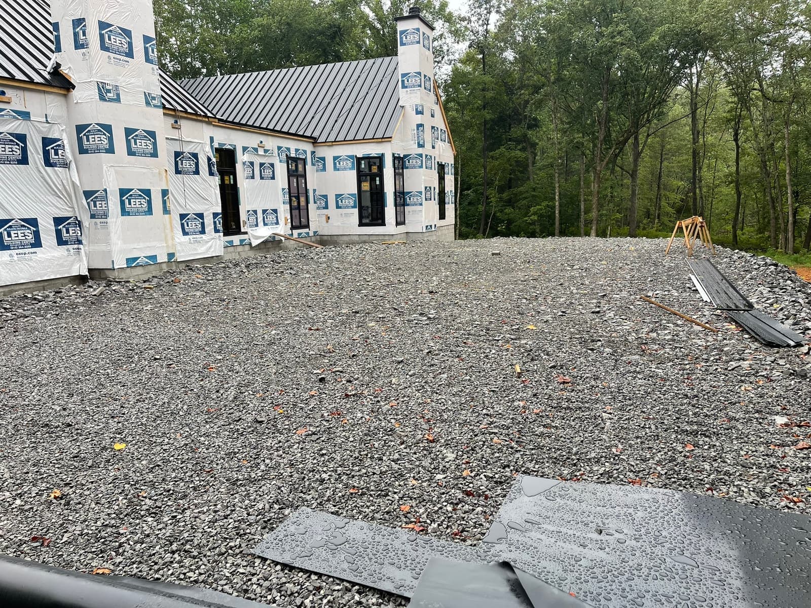 The wrapped house with black windows set, gravel drive.