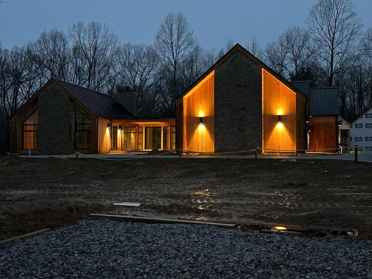 The house at night in snow, lit from inside.