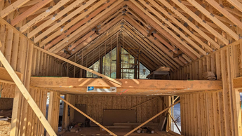 Janesse's Residence, a building site in Leadville, CO, a wooden frame of a building under construction with large windows.