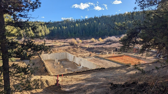 Janesse's Residence, a building site in Leadville, CO, with a basement foundation of a building in a forested area with clear blue sky.
