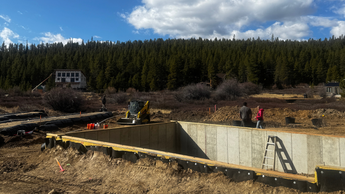 Janesse's Residence, a building site in Leadville, CO, a construction site with a large concrete foundation in a forested area.