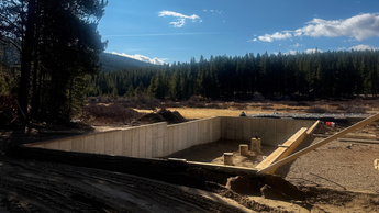 Janesse's Residence, a building site in Leadville, CO, a foundation of a building under construction with a forest and blue sky in the background