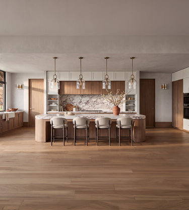 Coyotes Den: A modern kitchen island with a marble countertop and backsplash, surrounded by five bar stools, set in a bright, open-plan kitchen with wood flooring and pendant lights.