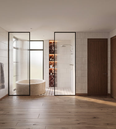 Coyotes Den: A modern bathroom interior with a freestanding round bathtub inside a glass-walled enclosure, a walk-in shower with black-framed glass doors, wood flooring, and white wall tiles.