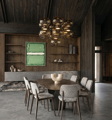 Casa del Prado - A modern dining room with a dark wood ceiling and built-in shelving, featuring a round wooden dining table surrounded by upholstered chairs. A large cluster chandelier hangs above, and a green framed artwork is mounted on the wall.