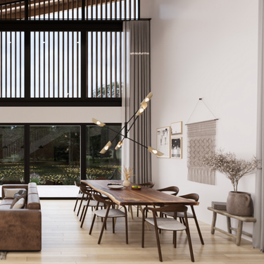 A modern open-concept dining and living space featuring a large wooden dining table with eight chairs, set under a striking contemporary chandelier with multiple light arms. The room has high ceilings with tall windows framed by vertical black slats, allowing ample natural light. Neutral tones dominate the space, with a cozy brown leather sofa, light wooden flooring, and minimalist wall decor including framed art, a macrame wall hanging, and a large vase with dried branches on a rustic bench.