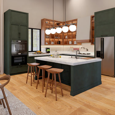 A modern kitchen with dark green cabinetry, warm wood open shelving, and a large white marble island with a built-in sink. The island is accompanied by three wooden barstools, and a sleek pendant light with globe fixtures hangs above. Stainless steel appliances, including a double oven and a refrigerator, complement the space. A window provides natural light, while under-cabinet lighting highlights the neatly arranged dishes and kitchen essentials. The space combines rustic and contemporary elements with it