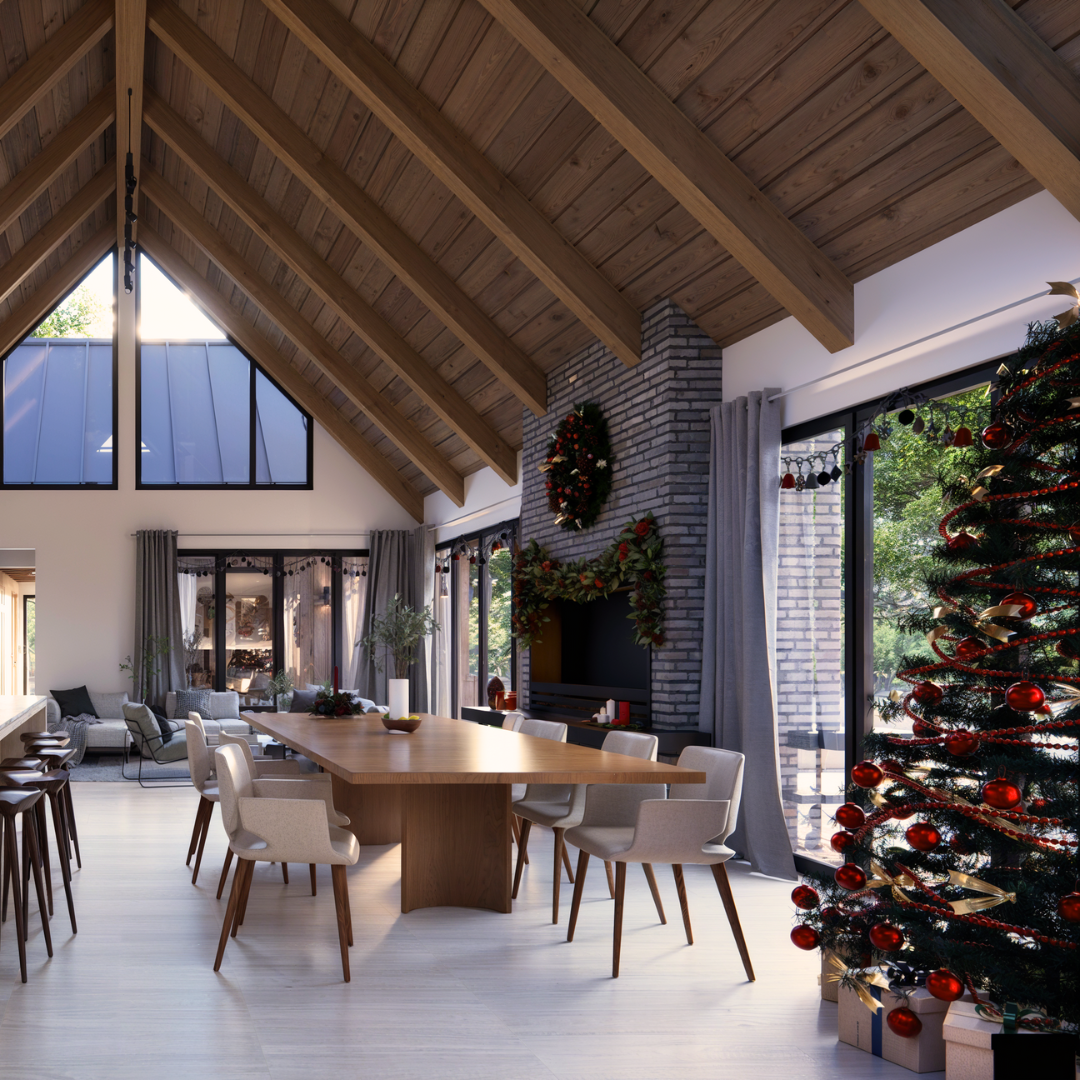 A dining area with a vaulted ceiling, seamlessly connected to the kitchen and living space in a cabin home design. Featuring a central stone chimney and tall open windows that provide views of the outdoors.