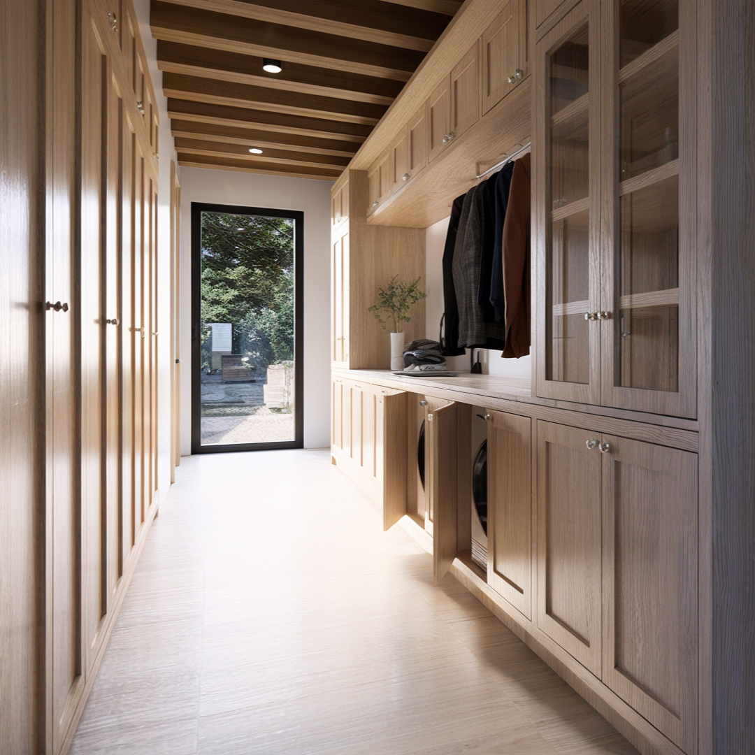 A minimalist interior hallway in Moose Meadow’s cabin, connecting the laundry closet with a glass door leading to the outdoors. The hallway transitions through a breezeway that links the common areas, while the wood cabinets and beamed ceiling create a warm and comforting interior design.