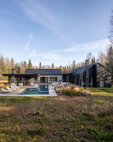 Modern house with a pool surrounded by trees and greenery in New York.