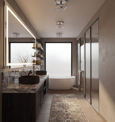 The Maine Project: A modern bathroom interior with a double vanity, marble countertop, black vessel sinks, a freestanding bathtub, walk-in closet doors, and a patterned runner rug on a light wood floor.