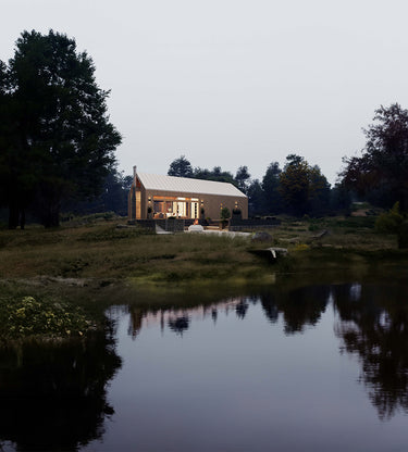 Front facade of nordic cabin design surrounding by trees on an open land near a pond