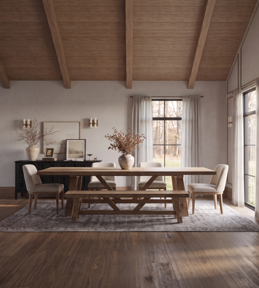 Coyotes Den: A rustic wooden dining table with matching bench and chairs, styled in a bright, modern dining room with a high wood-beamed ceiling and large windows.